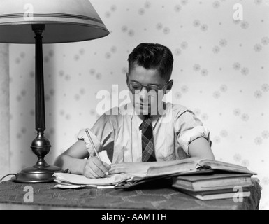 1940ER JAHRE JUNGE TRÄGT BRILLE STUDIUM SCHREIBEN Stockfoto