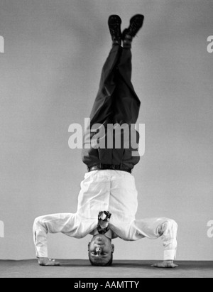 1950ER JAHRE MANN IN HEMD UND KRAWATTE AUF KOPF STEHEN Stockfoto