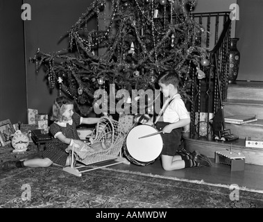 1930S 1940S JUNGEN UND MÄDCHEN SPIELEN MIT SPIELZEUG UND GESCHENKE VON WEIHNACHTSBAUM Stockfoto