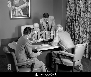 SITZUNG DER 1950ER JAHRE DER MÄNNER ANZÜGE SCHREIBTISCH Stockfoto