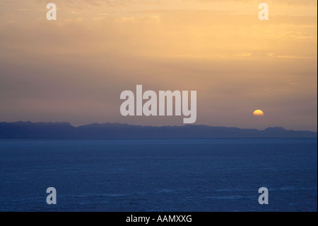 Die Sonne bricht durch die Wolken über die fernen Berge und große Salzsee Salinen am Chott el Djerid Tunesien Stockfoto