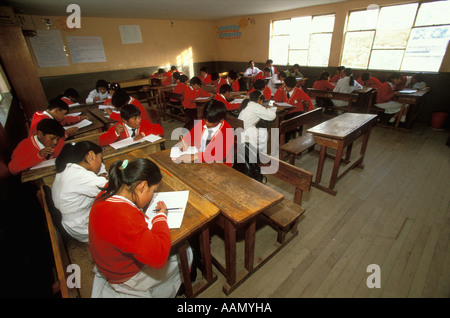 Studenten in Uniform arbeiten auf ihre Aufgaben im Unterricht an einer Schule in Oruro, Bolivien Stockfoto