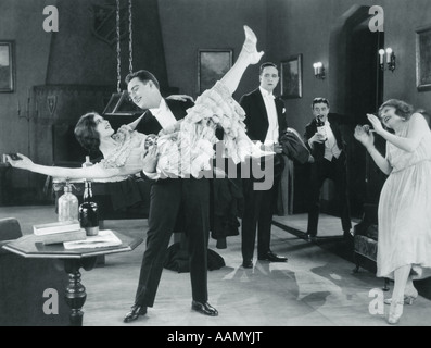 1920ER JAHRE FILM IMMER NOCH DER WILDE PARTY MIT FRAU FLAPPER GEDREHT UPSIDE-DOWN IN ARMEN EINES MANNES TANZEN Stockfoto