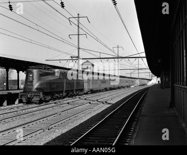 1940ER JAHREN PENNSYLVANIA RAILROAD STRAFFEN ELEKTRISCH ANGETRIEBENE GG1 LOKOMOTIVE ZIEHEN PERSONENZUG AUS STATION Stockfoto