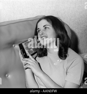 BRÜNETTE TEEN GIRL FRAU TRANSISTOR-RADIO 1950S 1960S MUSIK HÖREN Stockfoto