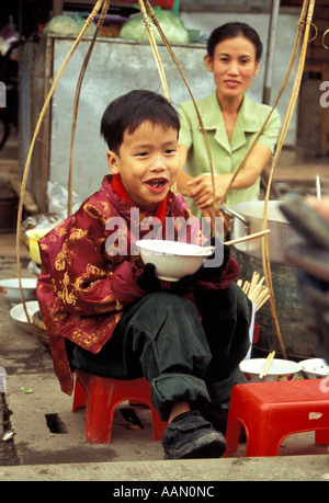 Kleiner Junge Essen vom Straßenstand, Hue, Vietnam Stockfoto