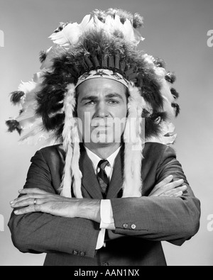 1960ER JAHRE PORTRAIT MANN TRAGEN INDIANERHÄUPTLING GEFIEDERTEN KOPFSCHMUCK Stockfoto