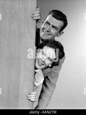 1950ER JAHREN PAAR BLICK HINTER TÜR Stockfoto