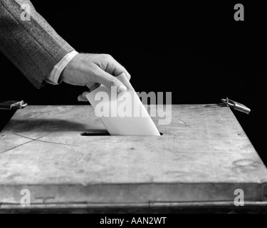 1930S 1940S MÄNNLICHE HAND FALLEN PAPIER STIMMZETTEL IN ABSTIMMUNG BOX Stockfoto