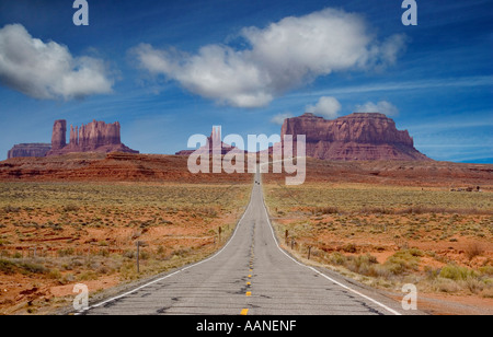 Klassischer Blick auf die US 163, die sich dem Monument Valley von Norden nähert, wo der Highway in Richtung der hoch aufragenden Buttes an der Grenze zwischen Utah und Arizona führt. Stockfoto