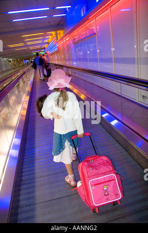Kleines Mädchen mit Puppe und Wagen am Flughafen München Stockfoto