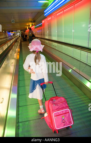 Kleines Mädchen mit Puppe und Wagen am Flughafen München Stockfoto