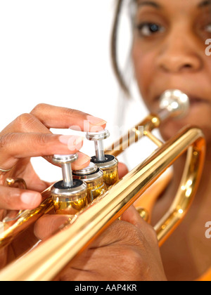 Junge zuversichtlich Ethnische Frau spielt eine Trompete Isoliert gegen einen weißen Hintergrund mit einen Freistellungspfad Stockfoto