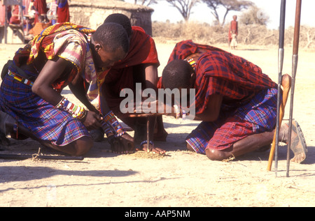 Gruppe von drei Maasai-Männer machen Feuer durch Reiben klebt zusammen südlichen Kenia in Ostafrika Stockfoto