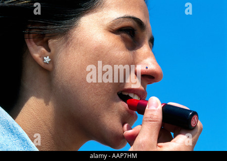 Junge Frau Anwendung Lippenstift. Model Released Stockfoto