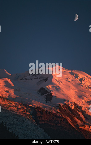 Der Mond aufgeht über den Gipfel des Mont Blanc gebadet in tief orange Licht der untergehenden Sonne, Chamonix, Frankreich Stockfoto