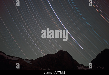 Eine 2-stündige Langzeitbelichtung Sterne zeigt Routen über die zackigen Umrisse der französischen Alpen Stockfoto