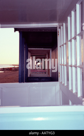 Blick durch eine Linie von Strandhütten auf einem Parkplatz für den Winter zum Schutz vor dem Meer und Wind, Southwold, Suffolk, UK Stockfoto