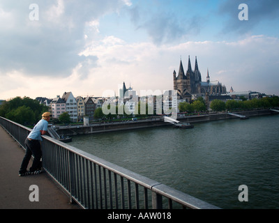 Junger Mann auf Rollerblades, bewundern die Skyline von Köln an einem schönen Herbsttag Stockfoto