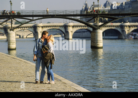 Paar küssen bei einem Spaziergang entlang der Ufer in der Nähe von Pont des Arts in Paris Stockfoto