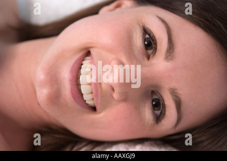 Lächelnde Frau auf Kissen closeup Stockfoto