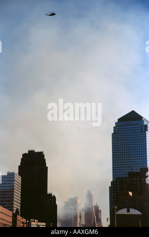 Ein einsamer Hubschrauber fliegen über der World Trade Center Site am 11. September 2001. Rauch aus dem Gebäude Zusammenbruch in der Luft Stockfoto