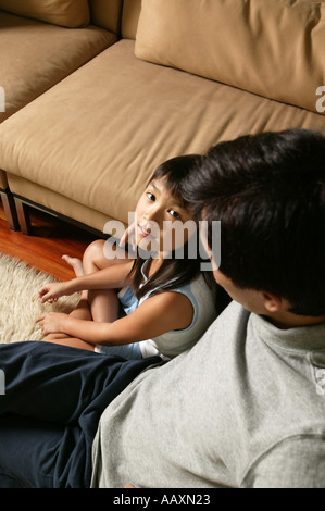Vater und Tochter sitzen auf Teppich Stockfoto