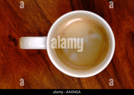 Über Kopf leeren Sie Kaffeebecher auf einem hölzernen Cafétisch Stockfoto