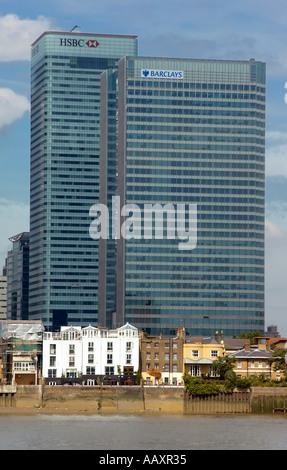 Die Türme am Canary Wharf in London in den Schatten stellen die älteren Wohnimmobilien am Ufer der Themse Stockfoto