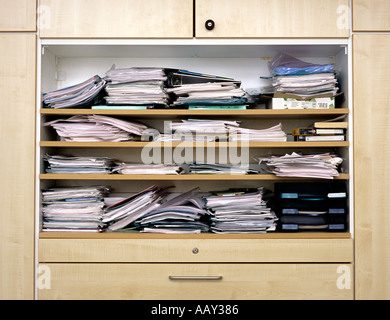 Nahaufnahme von Aktenschrank mit unordentlichen Stapel von Papieren Stockfoto