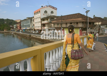 RSC78648 Frau in gelb Saree gonna work über alte Pato Brücke Goa Indien Stockfoto