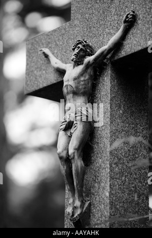 Jesus Christus am Kreuz gekreuzigt trägt eine Krone aus Dornen Statue auf einem Grabstein Kreuz Stockfoto