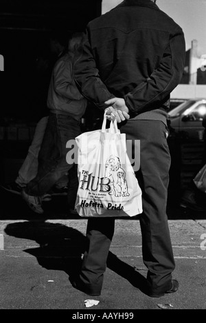 Mann mit weißer Tasche in schwarzer Kleidung Stockfoto