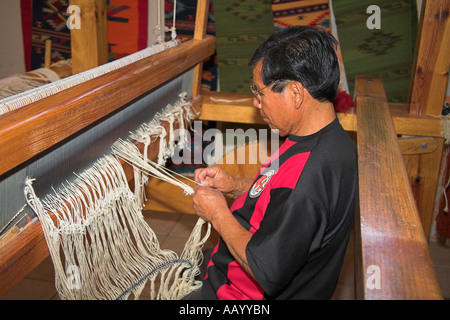 Mann die Quasten während Hand gemacht Teppich herzustellen, Teotitlan del Valle, in der Nähe von Oaxaca, Bundesstaat Oaxaca, Mexico Stockfoto