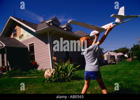 Kleiner Junge spielt mit Modellflugzeug im Hinterhof des Hauses Stockfoto