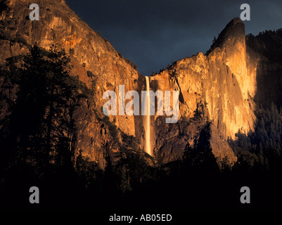 Dunkle Gewitterwolken über Bridalveil Fall zu sammeln, wie die Sonne die Felswand im Yosemite-Nationalpark, Kalifornien leuchtet Stockfoto