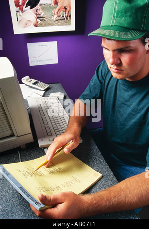 Landwirtschaft - Molkerei-Bauer arbeiten am Computer in seinem Büro Bauernhof / Janesville, Wisconsin, USA. Stockfoto