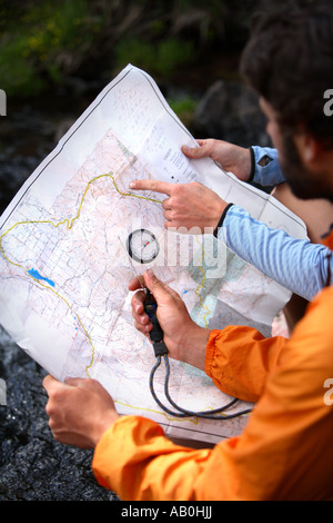 Wanderer auf der Suche auf Karte und Kompass Stockfoto