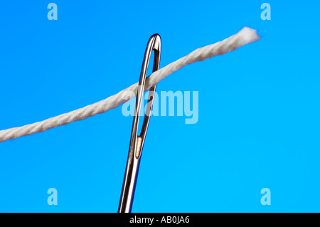 Faden Sie in ein Nadelöhr Stockfoto