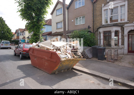 Überspringen in der Straße und vorne Garten voller Müll außerhalb privaten Wohnungsbau Chingford North East London UK Stockfoto