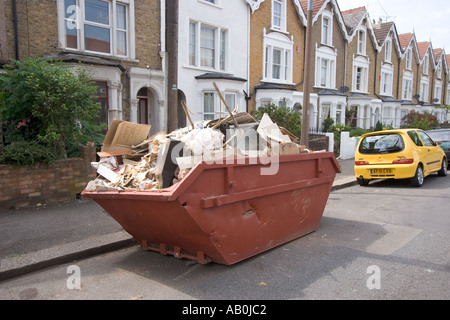 Überspringen in der Straße und vorne Garten voller Müll außerhalb privaten Wohnungsbau Chingford North East London UK Stockfoto