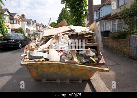 Überladene Skip in der Straße voller Müll außerhalb privaten Wohn-Gehäuse Chingford North East London UK Stockfoto