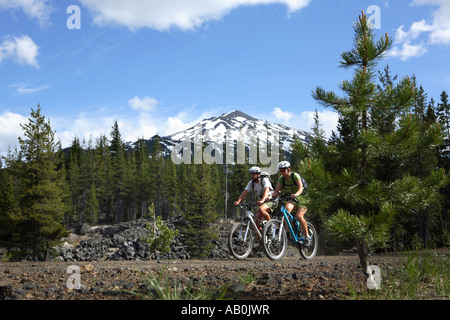 Junges Paar Mountainbike zusammen mit Berg im Hintergrund Stockfoto