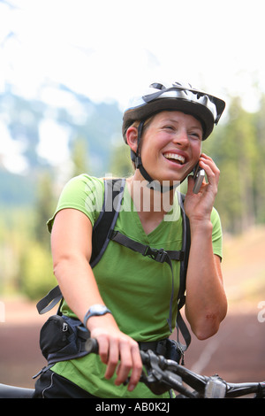 Junge Frau mit Mountainbike reden über Handy Stockfoto