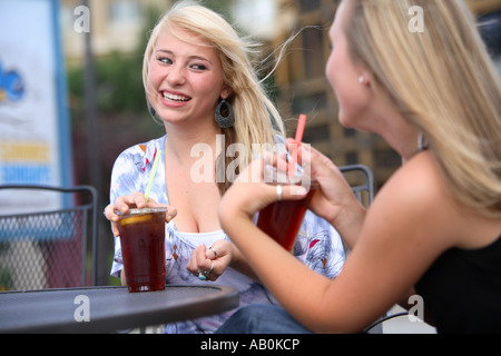 Freundinnen sitzen zusammen in einem Straßencafé sprechen Stockfoto