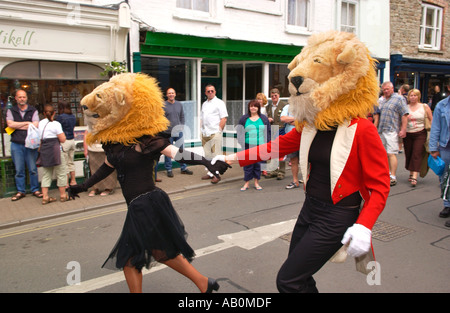 Interpreten mit Löwenköpfen aus Giffords Zirkus tanzen in die Straße am Heu auf Wye Powys Wales UK Stockfoto