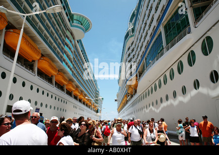 Zwei Kreuzfahrtschiffe mit Menschen dazwischen aussteigen nebeneinander angedockt Stockfoto