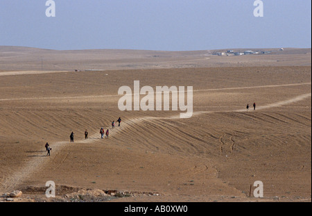 Querformat mit Negev Beduinen zu Fuß in Richtung beduinenlager am fernen Horizont, Wüste Negev, Israel, Naher Osten Stockfoto