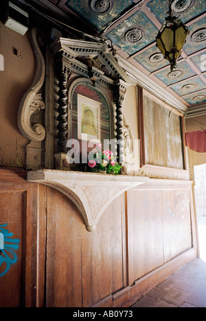 Eine alte devotional Schrein in die Einfahrt von einer engen Gasse durch eine Terrasse von Häusern Stockfoto