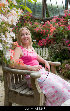 Frau Entspannen im Sommerhaus voller Pflanzen UK Norfolk Stockfoto